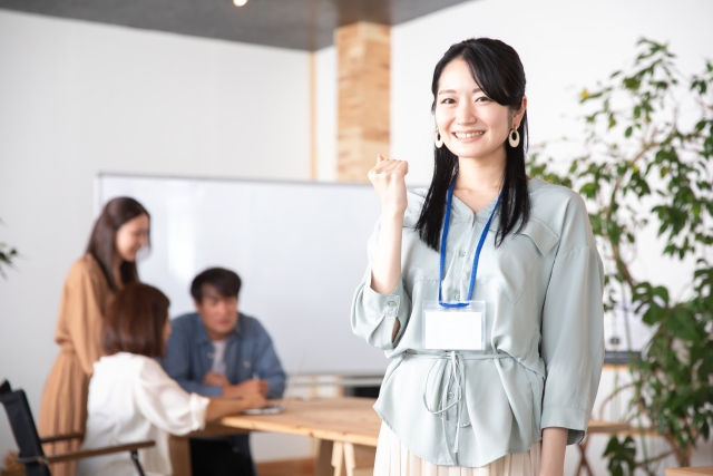 職場でガッツポーズをする女性