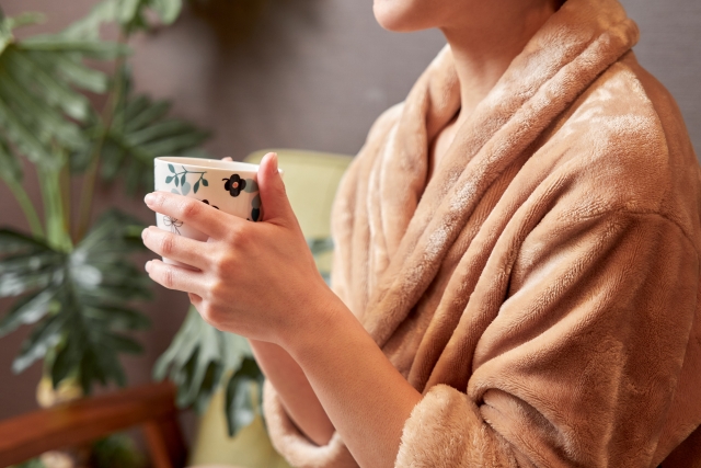 お風呂上がりにリラックスしながらお茶を楽しむ女性の手元