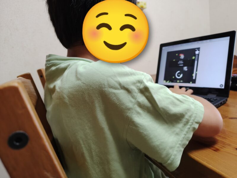 Popタイピングをノートパソコンで練習する小学生の後ろ姿